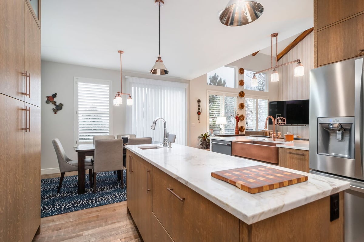 Littleton, CO whole home renovation kitchen with large island, copper sink, and open dining area by Cillessen Construction