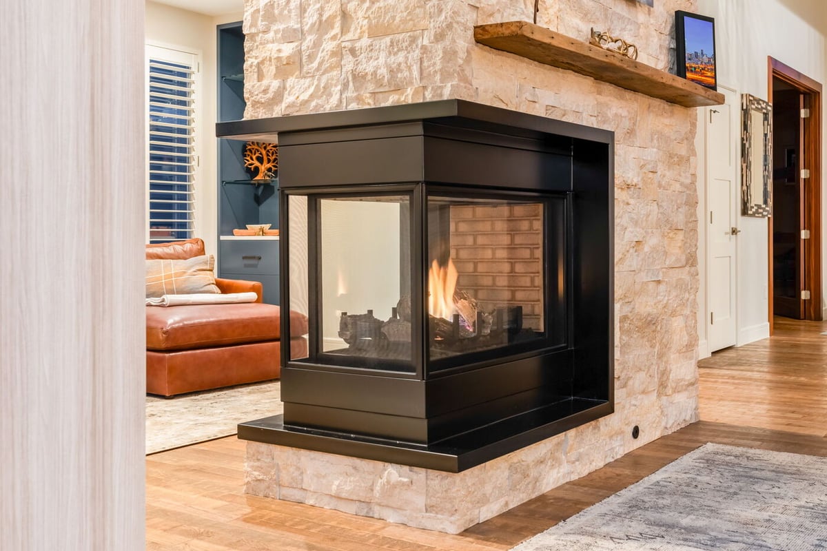Littleton, CO whole home renovation living room with stone fireplace and modern glass enclosure by Cillessen Construction