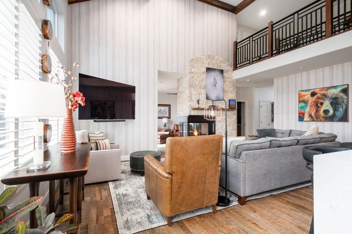 Littleton, CO whole home renovation living room with vaulted ceilings, stone fireplace, and modern furnishings by Cillessen Construction