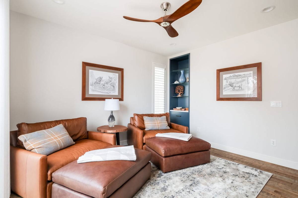 Littleton, CO whole home renovation seating area with leather chairs, ottomans, and built-in shelving by Cillessen Construction