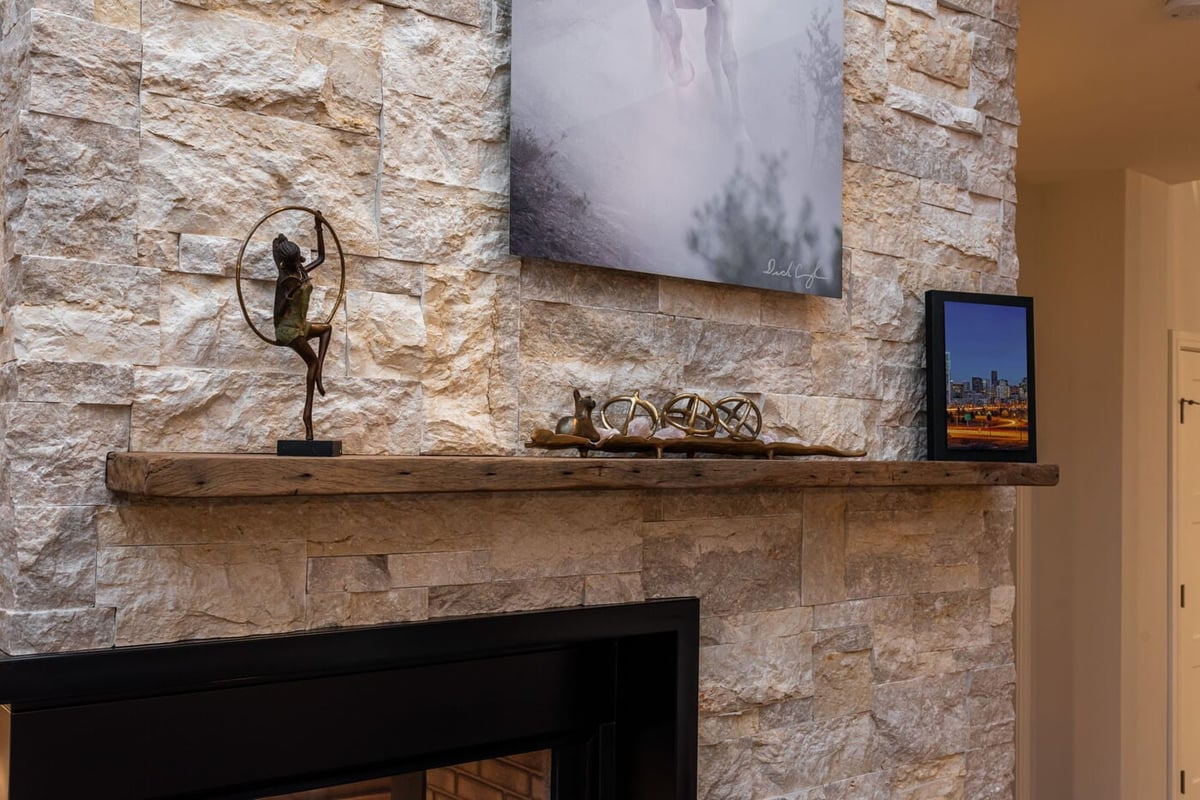 Littleton, CO whole home renovation stone fireplace mantel with decor and artwork by Cillessen Construction