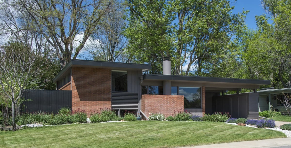 Applewood, CO custom home exterior with mid-century design, large windows, and greenery by Cillessen Construction