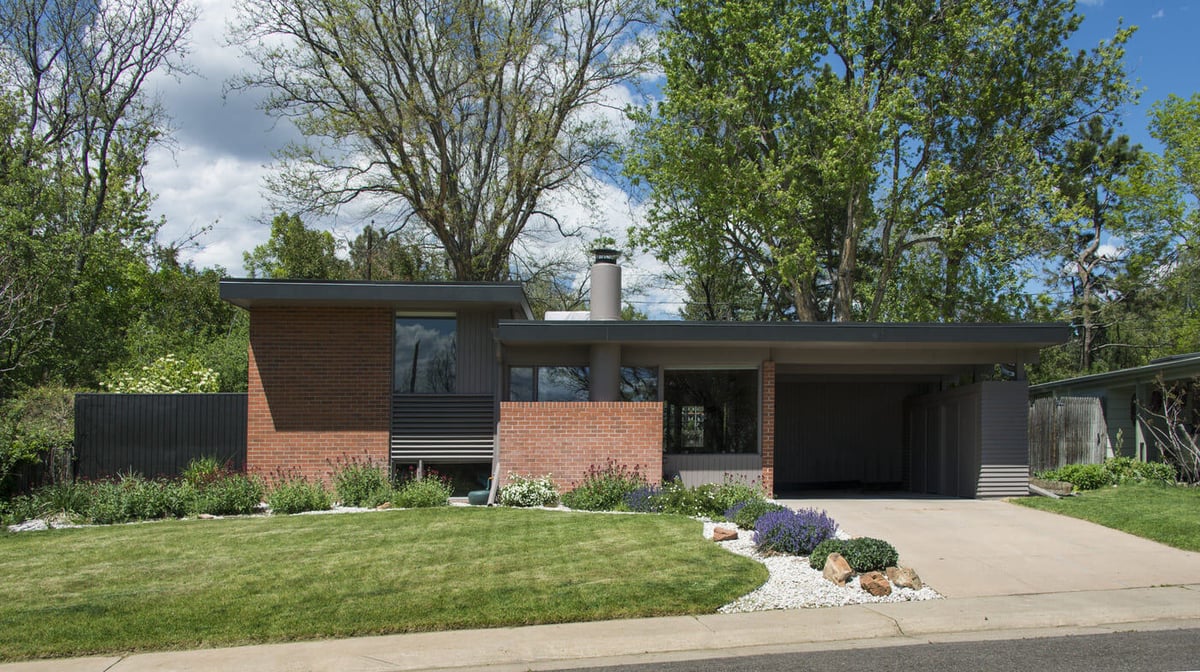 Applewood, CO custom home front elevation with carport, brick accents, and manicured lawn by Cillessen Construction