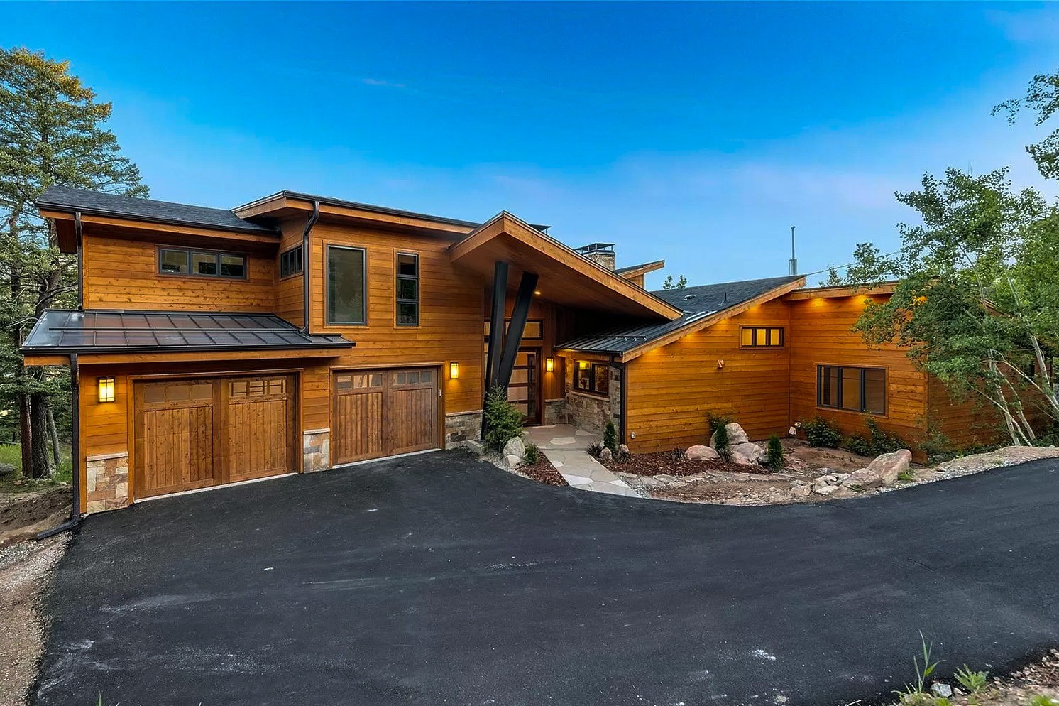 denver-colorado-modern-mountain-home-exterior-by-cillessen-construction-company-with-wood-siding-and-three-car-garage