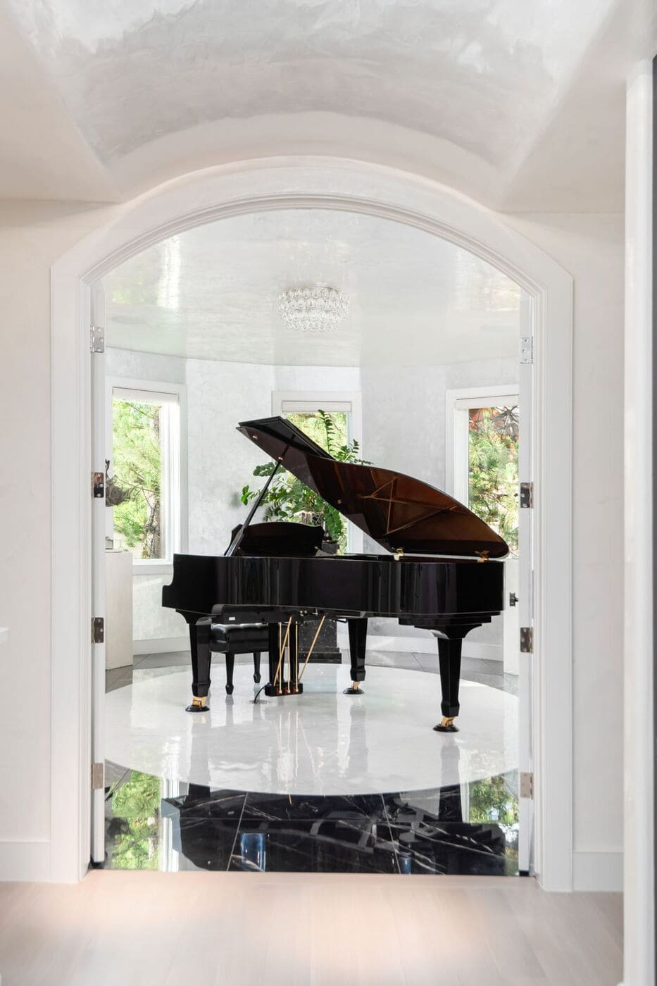 Greenwood Village, CO grand piano framed by arched doorway and windows, renovation by Cillessen Construction