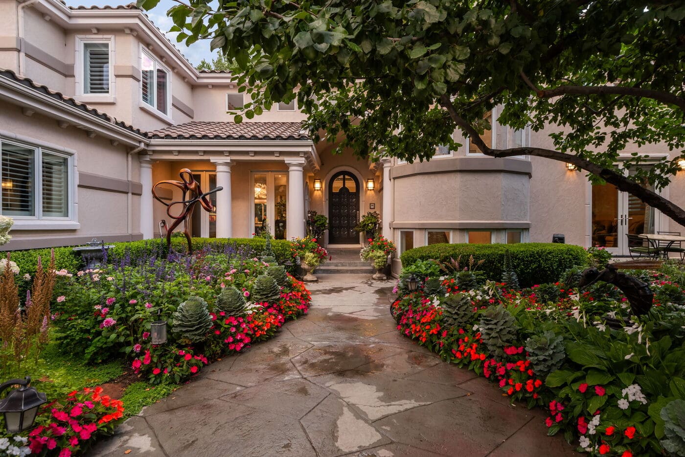 Greenwood Village, CO home exterior with lush landscaping, garden path, and entryway by Cillessen Construction renovation