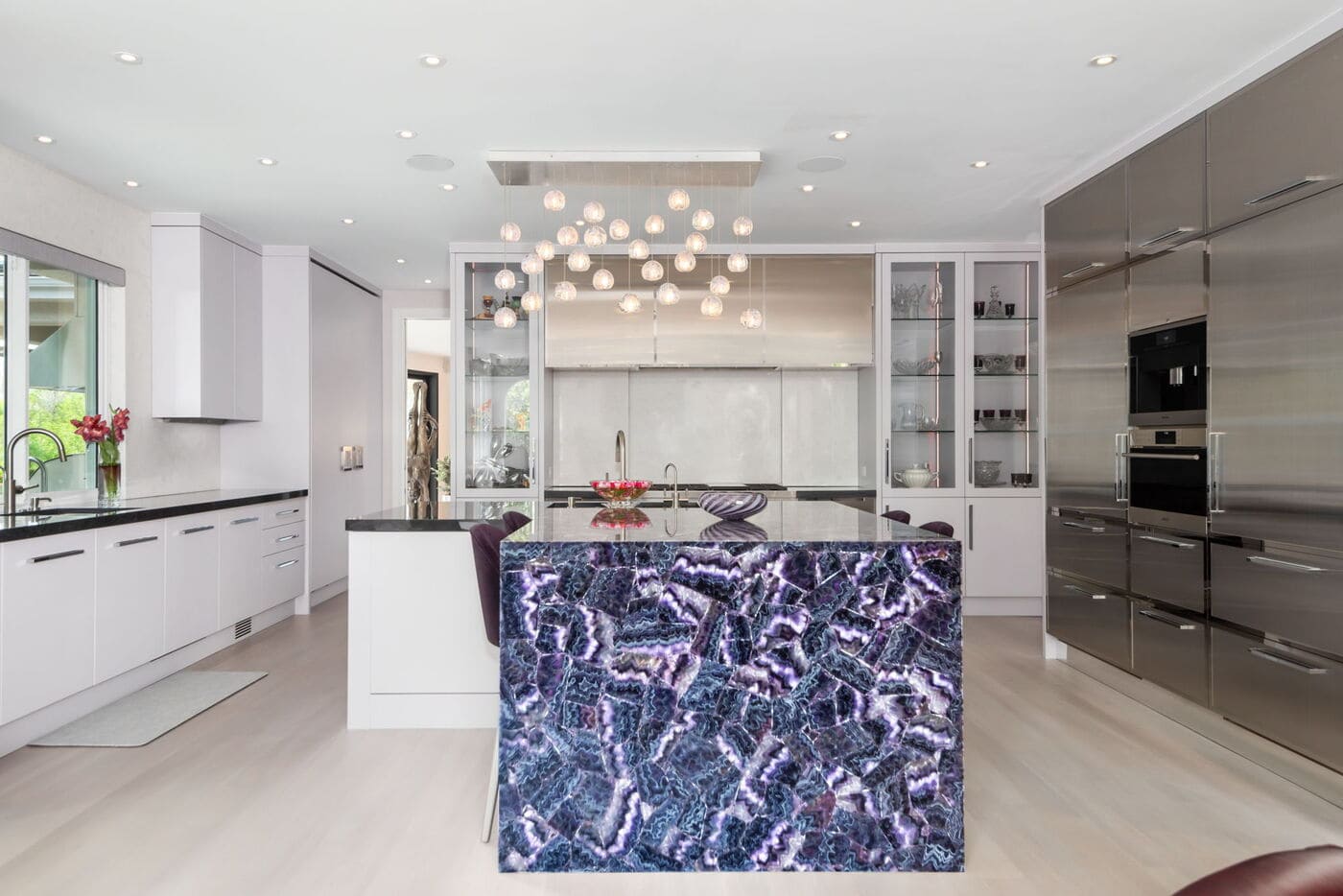 Greenwood Village, CO kitchen renovation with purple stone island, modern lighting, and sleek cabinetry by Cillessen Construction