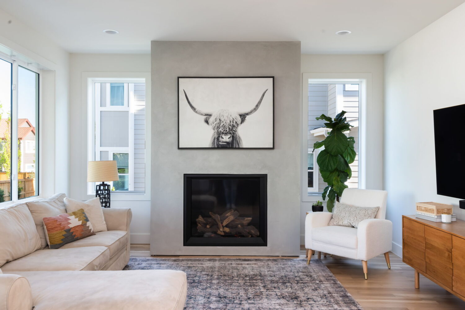 Living room with fireplace, large windows, and modern decor in custom home in Louisville, CO by Cillessen Construction