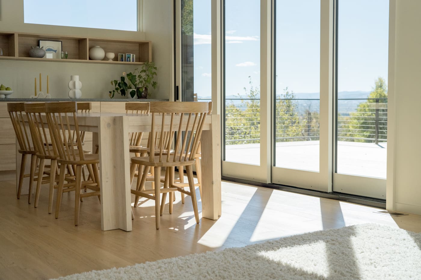 Dining area with wood table and chairs by sliding doors in Arvada, CO pop top renovation by Cillessen Construction