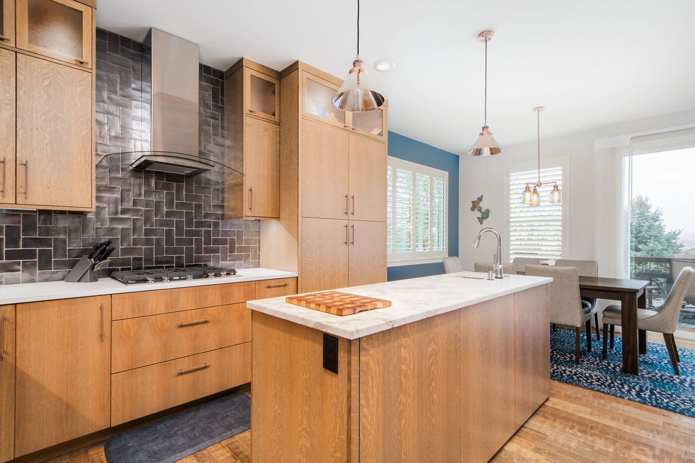Littleton, CO whole home renovation kitchen with island seating, wood cabinetry, and modern lighting by Cillessen Construction